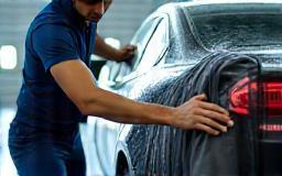 Technician cleaning car exterior